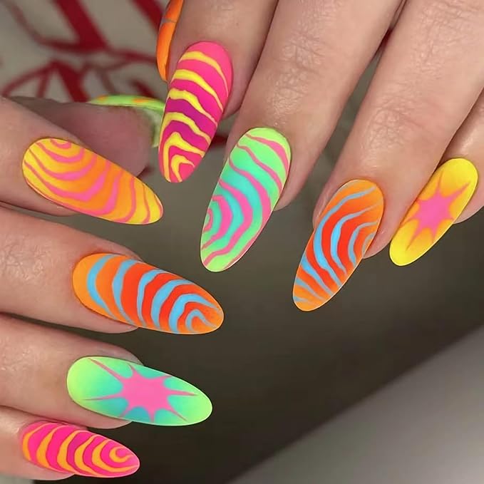 Sweet strawberry-inspired nail art with red swirls and fruity detailing.

