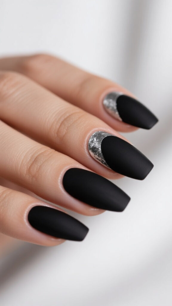Matte black coffin nails with silver foil accents, minimalist and trendy design for 2025.